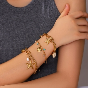 Marine style layered gold bracelet set with starfish shell pendants and pearls