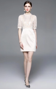 Detail of elegant lace patchwork dress with intricate beading and short sleeves
