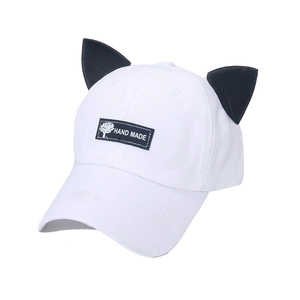 Détail des oreilles de chat et de la broderie 'HAND MADE' sur cette casquette blanche