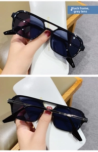 Detail view of stylish black sunglasses featuring gray lenses and retro double bridge design