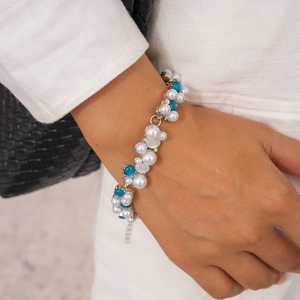 Detail of beaded necklace with white pearls and blue translucent beads on silver chain