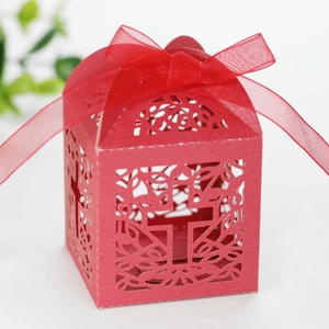 Macro shot of red laser-cut candy box featuring cross pattern and ribbon bow