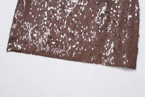 Gros plan détaillé des paillettes bronze scintillantes et des coutures sur cette mini-jupe