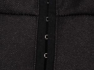 Detailansicht eines schwarzen Jeanskleids mit Korsett-Verschluss aus Metallhaken und Ösen