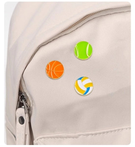 Detailansicht von Basketball-, Tennis- und Volleyball-Anstecknadeln auf Stofftasche