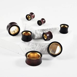Sandalwood and gold stainless steel ear gauges displayed on white stones