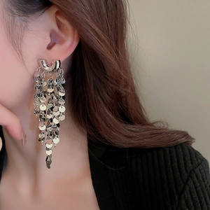 Macro detail of silver long tassel earrings with sparkling round sequins and U-shaped studs