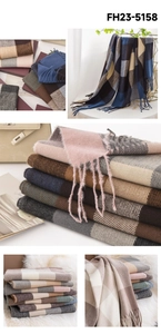 Close-up of stacked colorful plaid scarves with soft fringe detail and warm texture