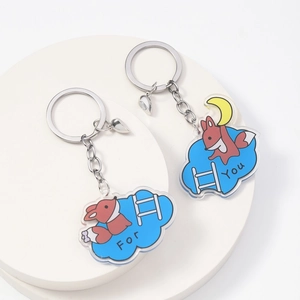 Detail of cute acrylic fox keychains with blue clouds and heart magnets for couples