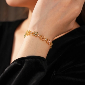 Detailansicht der Blumenarmband mit bunten Zirkonia-Tropfen auf goldener Beschichtung