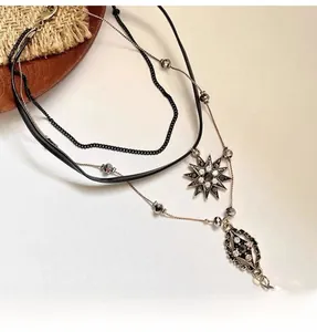 Detail of layered bohemian necklace featuring an octagonal star and diamond-set pendants