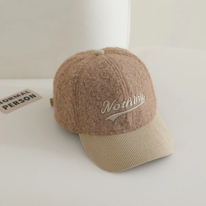 Détail de la broderie Nothing sur casquette en laine d'agneau marron et velours côtelé
