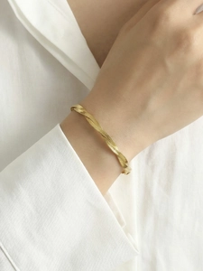 Detail of twisted 18k gold plated herringbone snake chain bracelet on a wrist