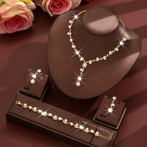 Elegant gold pearl necklace, bracelet and earrings set displayed on a jewelry stand
