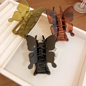 Minimalist butterfly hair claws in amber, olive green, and black acrylic colors
