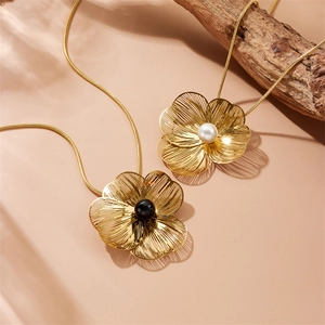 Golden flower necklaces with black and white pearls on elegant snake chains for women