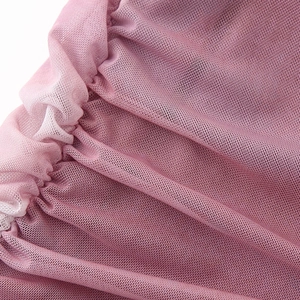 Close-up of mauve mesh fabric on a slim fit dress with textured pleats and soft drape