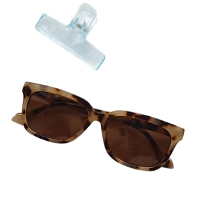 Retro tortoise shell cat eye sunglasses with light blue hair clip on white background