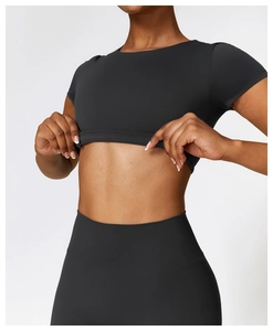 Detail eines mattschwarzen Yoga-Crop-Tops und hoch taillierter Fitness-Leggings