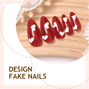 Detail of red cat-eye almond fake nails with white heart patterns on a wooden display