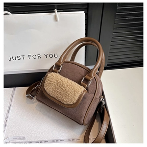 Close-up of brown suede texture and beige plush pocket detail on a stylish handbag