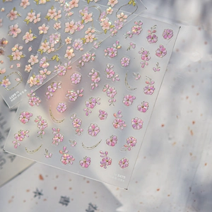 Detail view of 3D embossed cherry blossom nail stickers with laser shell glow effect