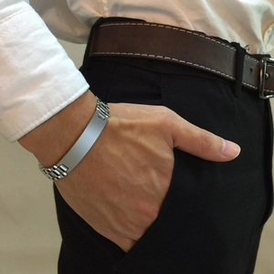 Macro shot of silver stainless steel watchband link bracelet on a male wrist in casual attire
