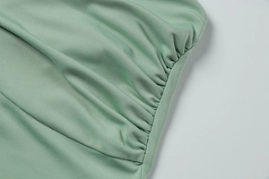 Detail of sage green ribbed knit fabric featuring side drawstring ruching and clean stitching