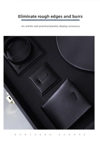 Detail of black textured leather jewelry organizer tray with gold metal latch and slots