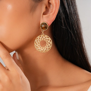 Tiger eye stone earrings with hollow gold lattice design shown on model for elegant look