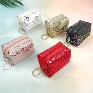 Detailed view of five colorful leopard print mini coin pouches with golden key rings