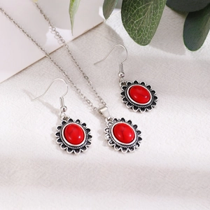 Détail d'un ensemble de bijoux bohème vintage avec pierres rouges et cadres fleuris argentés