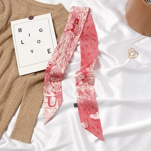 French vintage red and white letter U printed silk skinny scarf displayed on fabric