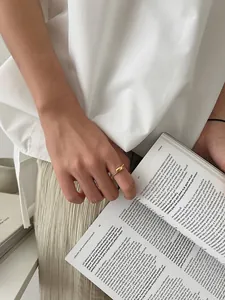 Detail of vintage beaded gold ring with oval accent held against a book background
