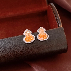 Macro shot of orange crystal gourd stud earrings with sparkling cubic zirconia pavé