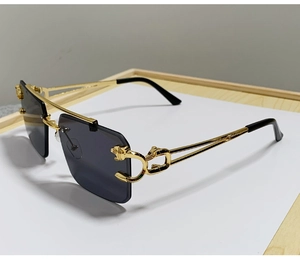 Detail showing golden cheetah head ornament on temple of rimless sunglasses