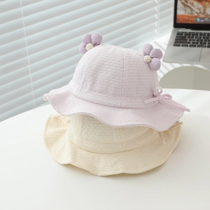 Detailed texture of baby bucket hats with 3D floral accents and soft waffle knit fabric
