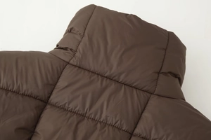 Vue macro détaillée du matelassage horizontal d'une veste en coton marron foncé