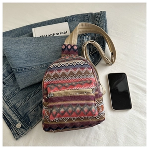 Close-up of bohemian woven chest bag with colorful geometric patterns and adjustable strap