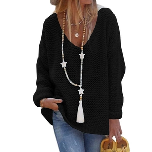 Detail of black V-neck knit sweater with chunky mesh texture and star beaded necklace
