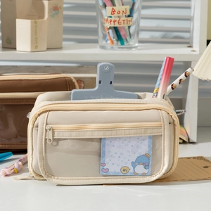 Detail view of large capacity cream pencil case with multiple layers and clear window