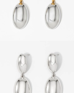 Macro detail of silver drop earrings with gold connector featuring smooth polished finish