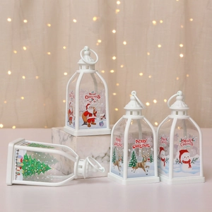 Set of four white Christmas lanterns with Santa and reindeer motifs on marble surface