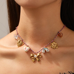 Bohemian woven cord necklace with rainbow, bow and heart charms worn by a model