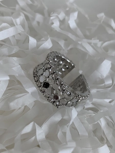 Detail view of silver honeycomb open ring with sparkling white zircon inlays on white paper