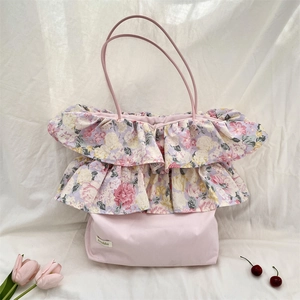 Dettaglio del bordo con volant a fiori rosa su una grande borsa tote in tela con manici