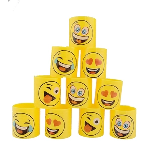 Close-up of ten yellow plastic spring toys featuring various printed emoji faces