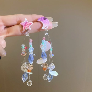 Detail of star and moon asymmetric floral earrings with colorful crystal tassels