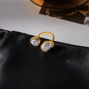 Macro detail of 18K gold stainless steel open ring with two baroque pearls on black leather