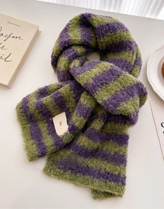Detailed texture of green and purple striped wool knit scarf with ins woven label